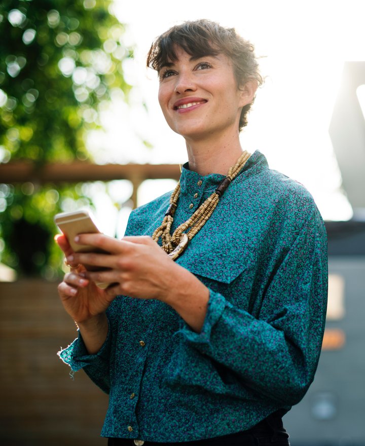 girl in green shirt looking at smartphone